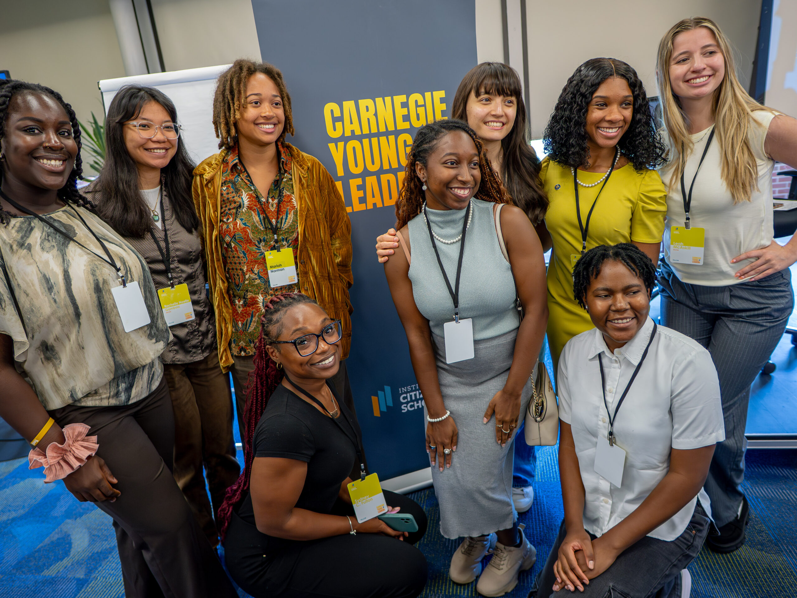 group of young people gathered in front of a sign