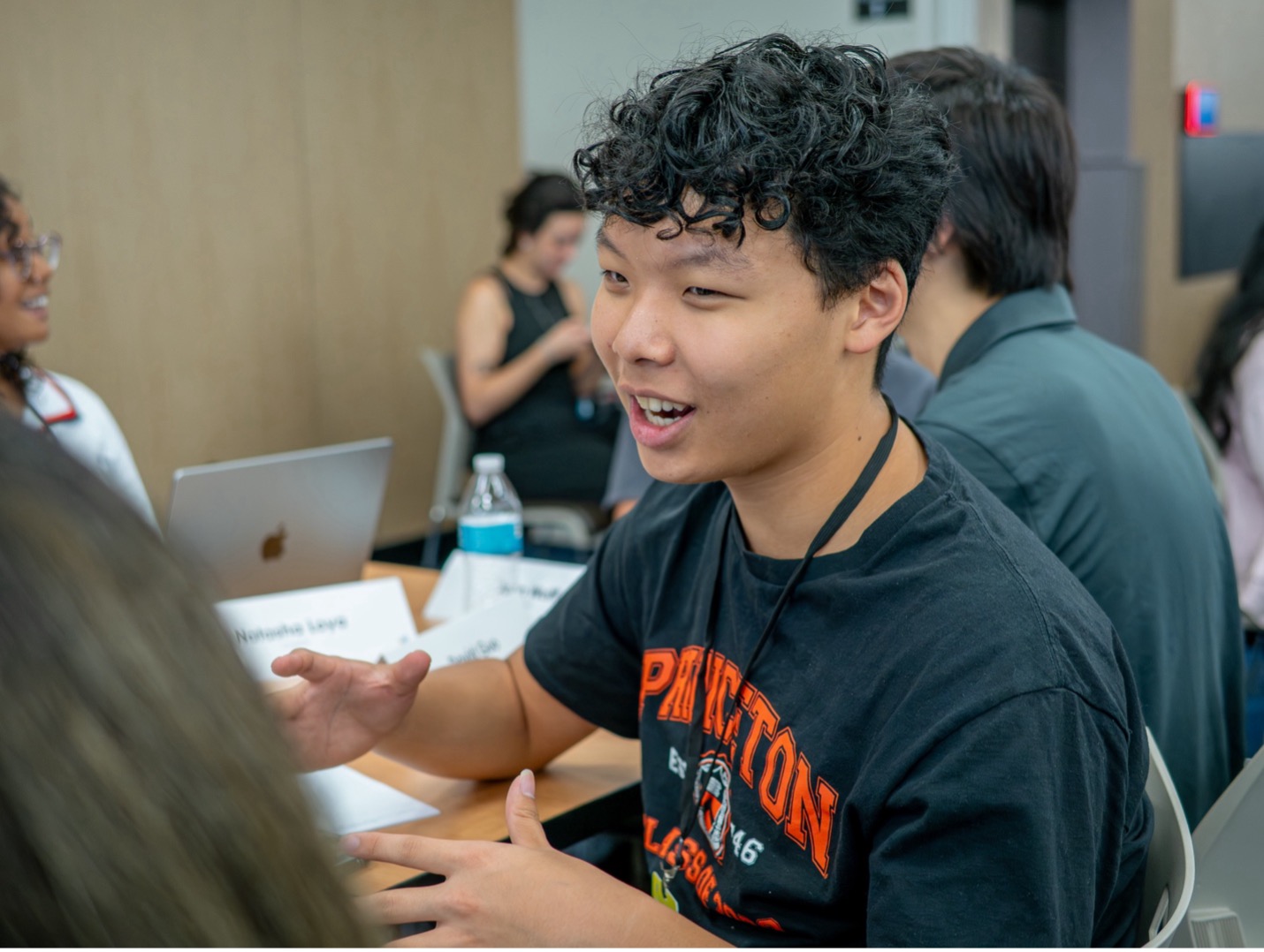 young person talking to someone else with their hands up